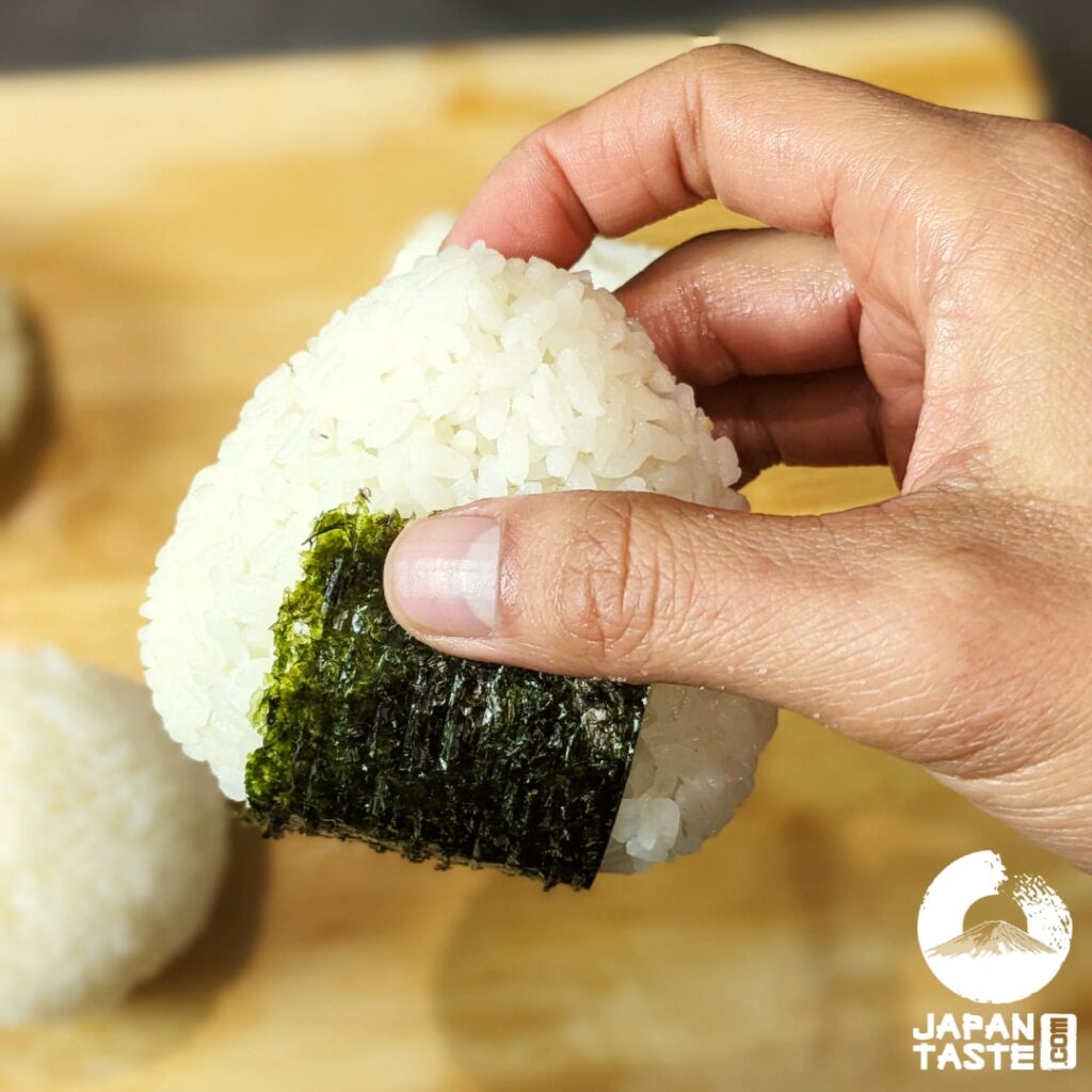 Let the nori stick to the bottom and behind the onigiri